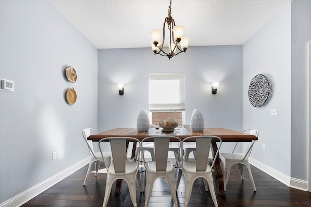 dining room featuring dark wood-type flooring, a chandelier, and a textured ceiling