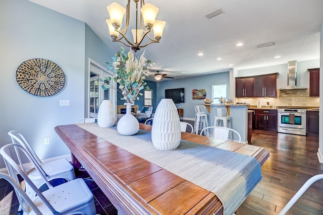 dining area featuring dark hardwood / wood-style flooring and ceiling fan with notable chandelier