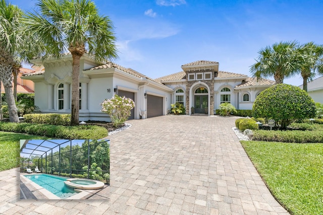 16 Hammock Beach Pkwy, Palm Coast, FL 32137 - mediterranean / spanish-style home with an attached garage, stucco siding, decorative driveway, a pool with connected hot tub, and stone siding