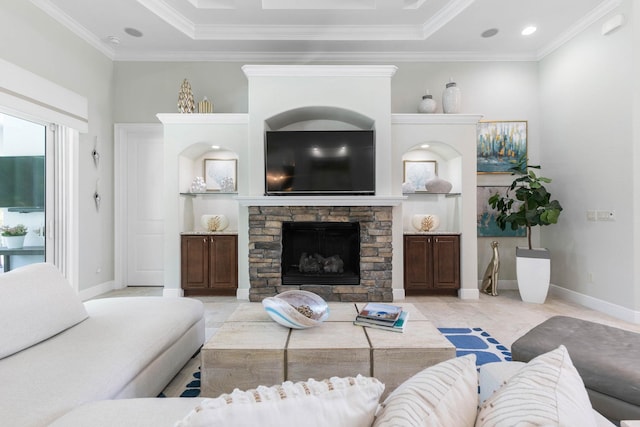 living room featuring crown molding, a stone fireplace, and a raised ceiling