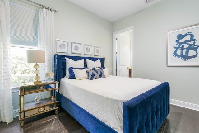 bedroom with dark hardwood / wood-style floors