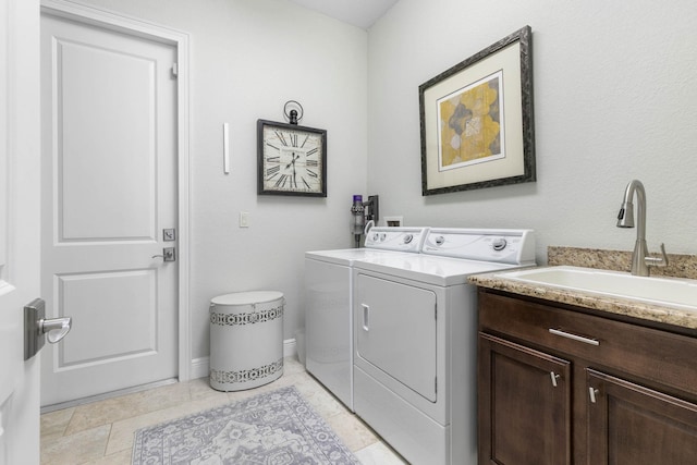 laundry room featuring sink, washer and clothes dryer, and cabinets