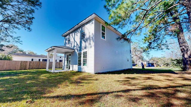 back of property featuring a lawn