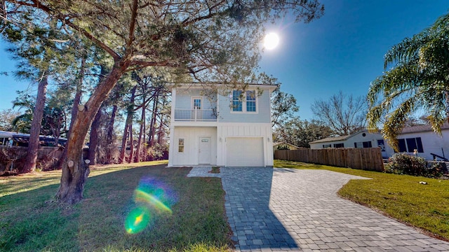 view of front of property with a garage, a front lawn, and a balcony