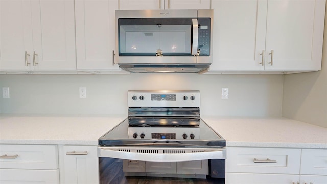 kitchen featuring white cabinetry, light stone counters, and appliances with stainless steel finishes