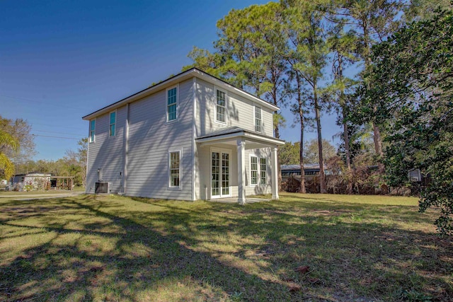 back of property with a yard and central AC unit