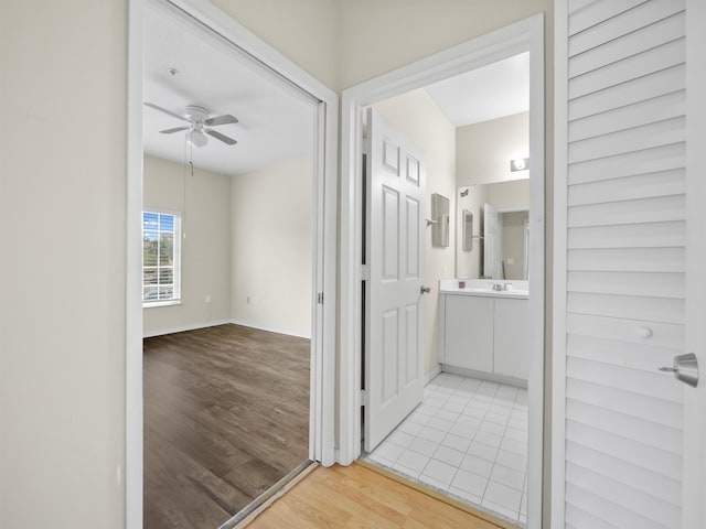 hallway with sink and light wood-type flooring