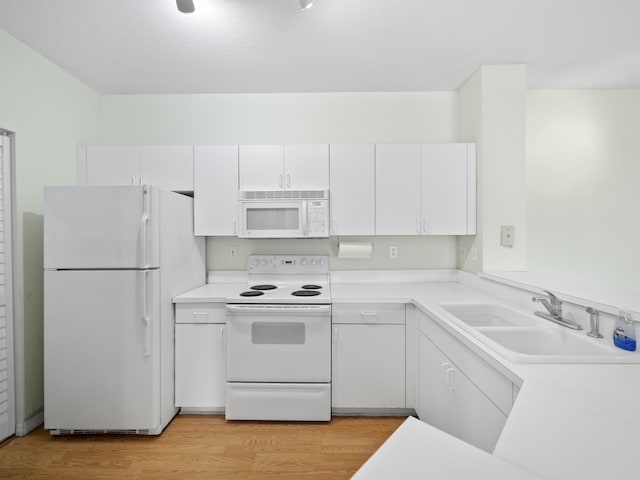 kitchen with sink, white cabinets, and white appliances