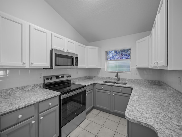 kitchen with gray cabinets, light countertops, appliances with stainless steel finishes, light tile patterned flooring, and a sink