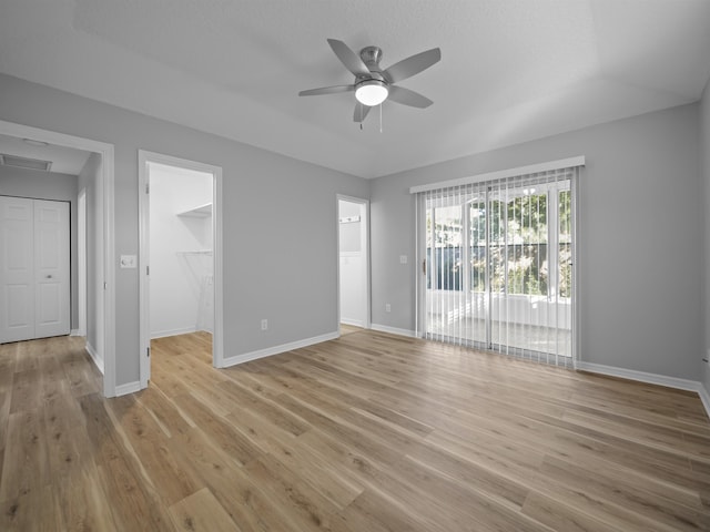 interior space featuring light wood-type flooring, baseboards, visible vents, and a ceiling fan