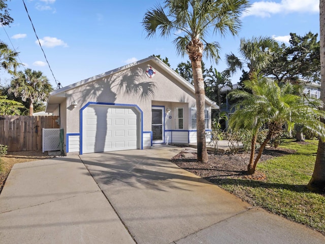 view of front of property featuring an attached garage, fence, concrete driveway, and stucco siding