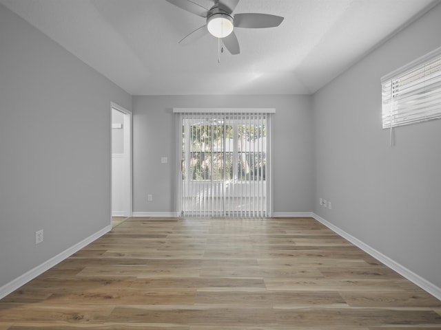 unfurnished room featuring a ceiling fan, light wood-type flooring, lofted ceiling, and baseboards