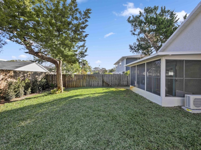 view of yard with ac unit, a sunroom, and a fenced backyard