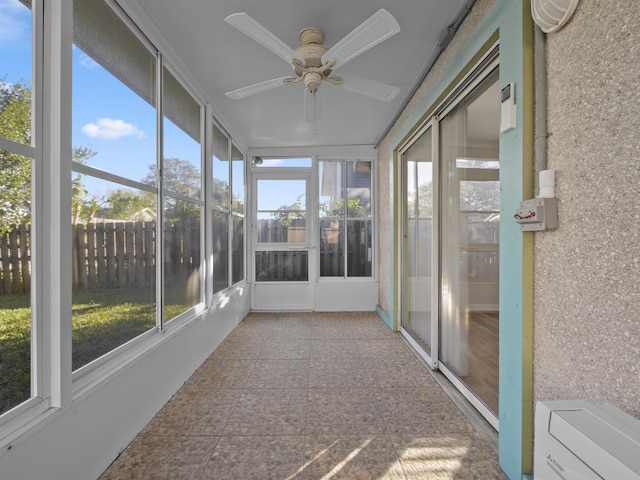 unfurnished sunroom with ceiling fan