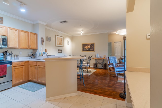 kitchen with kitchen peninsula, stainless steel appliances, ornamental molding, and light tile patterned floors