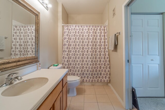 bathroom with vanity, tile patterned flooring, toilet, and walk in shower