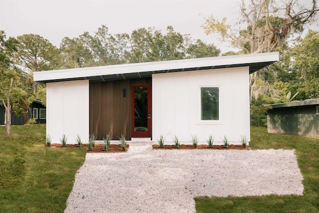 view of front facade featuring a front lawn and a storage shed