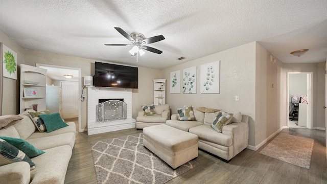 11428 Rustic Pines Cir, Jacksonville, FL 32257 - living room with ceiling fan, a fireplace, a textured ceiling, wood finished floors, and baseboards
