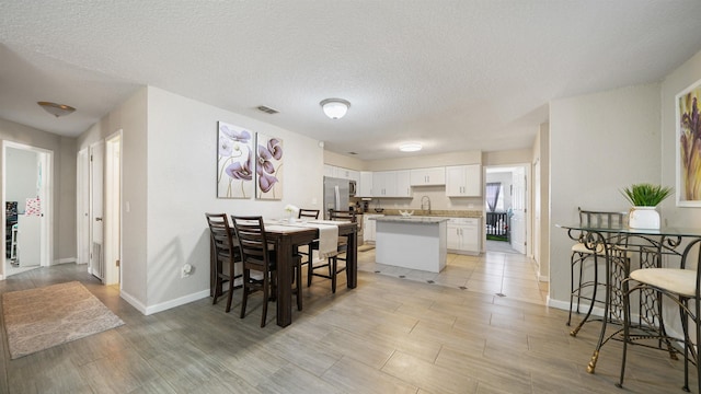 11428 Rustic Pines Cir, Jacksonville, FL 32257 - dining space with baseboards, a textured ceiling, and light wood-style flooring