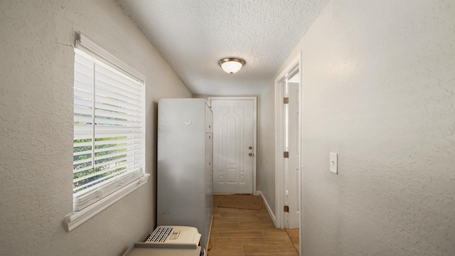11428 Rustic Pines Cir, Jacksonville, FL 32257 - hall featuring a textured ceiling, a textured wall, wood finished floors, and baseboards