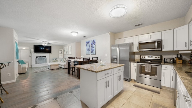 11428 Rustic Pines Cir, Jacksonville, FL 32257 - kitchen with appliances with stainless steel finishes, ceiling fan, a textured ceiling, and white cabinets