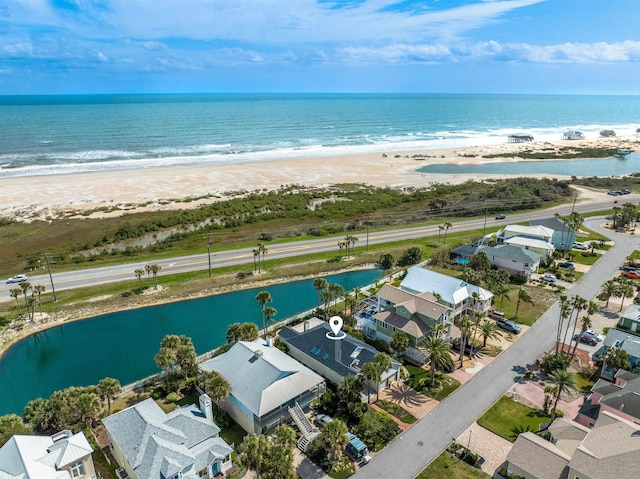 drone / aerial view featuring a water view and a beach view