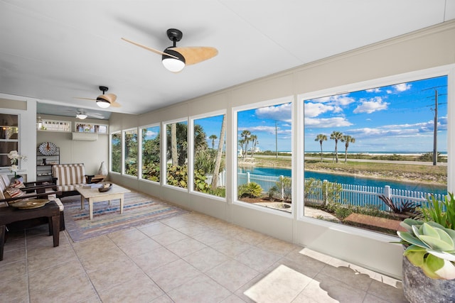 sunroom / solarium featuring a ceiling fan and a water view