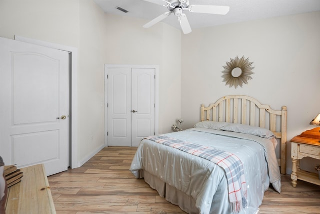 bedroom featuring visible vents, lofted ceiling, light wood-style floors, a closet, and a ceiling fan