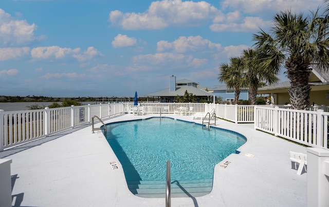 community pool with fence and a patio area