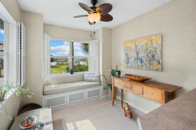 sitting room featuring light tile patterned flooring, baseboards, and a ceiling fan