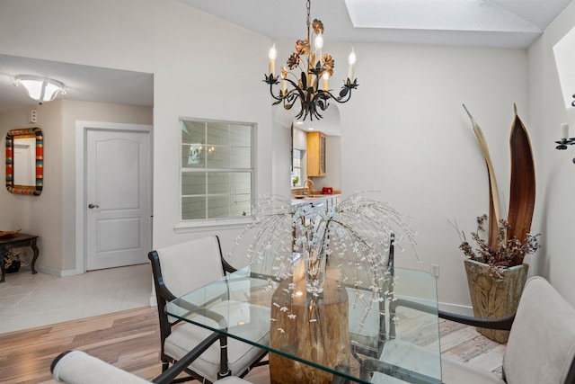 dining room featuring a chandelier, baseboards, and light wood-style flooring