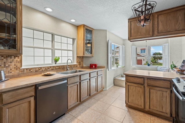 kitchen with a sink, tasteful backsplash, stainless steel dishwasher, and light countertops