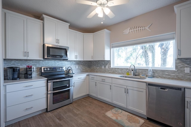 kitchen with a sink, light countertops, white cabinetry, and stainless steel appliances