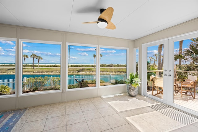 unfurnished sunroom featuring french doors, ceiling fan, and a water view