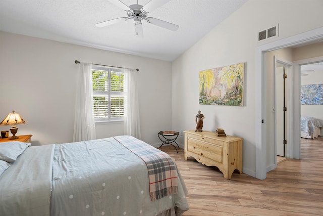 bedroom with visible vents, light wood-style flooring, a ceiling fan, a textured ceiling, and baseboards