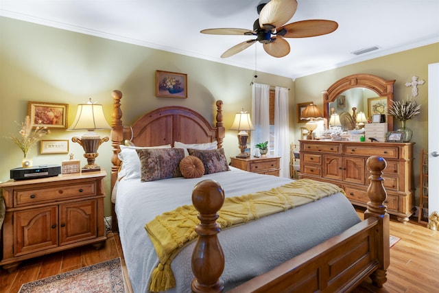 bedroom with ceiling fan, light hardwood / wood-style floors, and crown molding