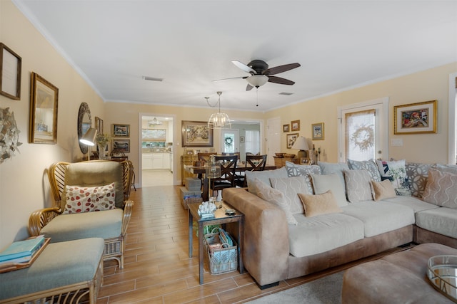 living room featuring ceiling fan, ornamental molding, and light hardwood / wood-style flooring