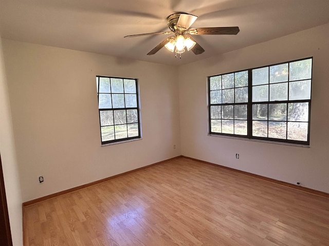 spare room featuring ceiling fan, a healthy amount of sunlight, and light wood-type flooring