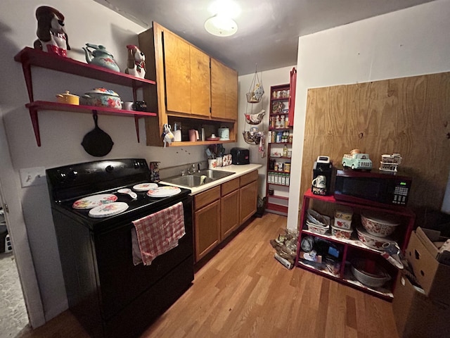 kitchen featuring sink, black appliances, and light hardwood / wood-style floors