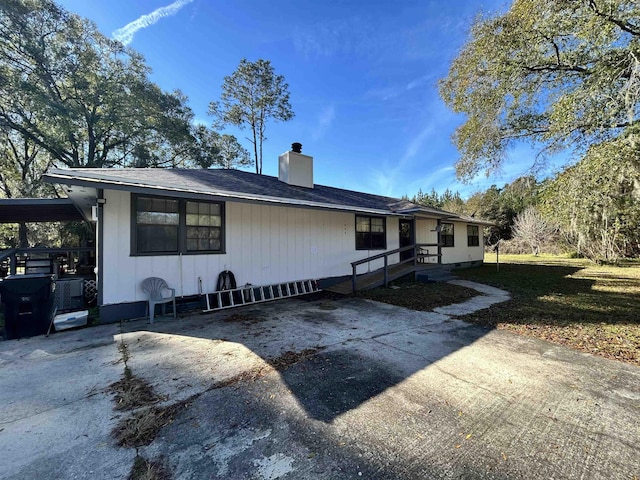 view of side of home with a yard and a carport