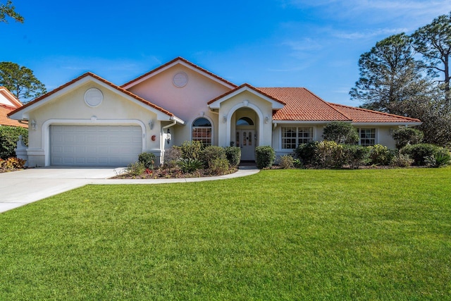 mediterranean / spanish home with a garage and a front yard