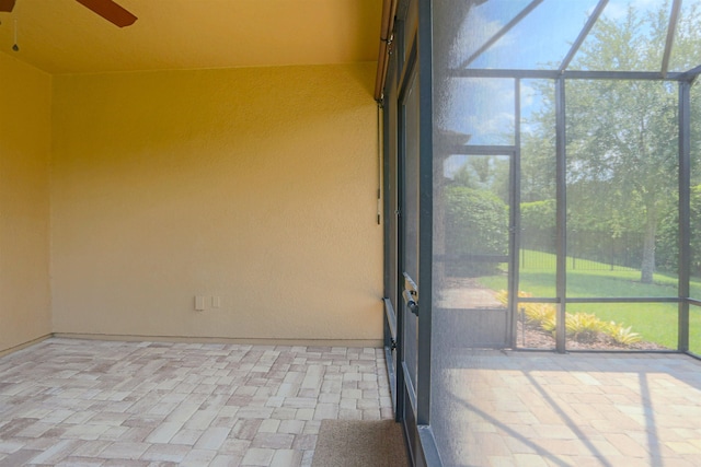 unfurnished sunroom featuring ceiling fan