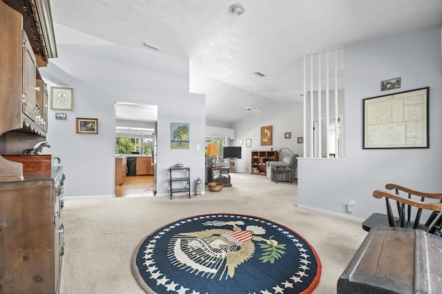 foyer with a ceiling fan, lofted ceiling, light carpet, and baseboards