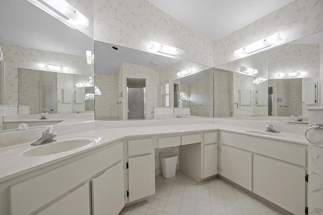 bathroom with wallpapered walls, a sink, and a stall shower