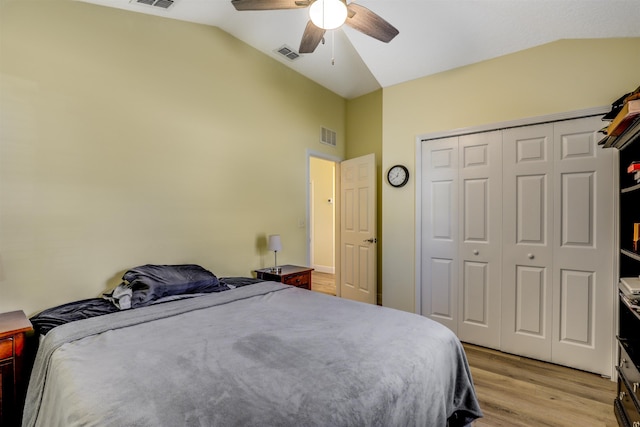 bedroom featuring light wood-style flooring, visible vents, and vaulted ceiling