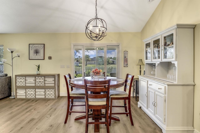 dining room featuring a chandelier, light wood-type flooring, and baseboards