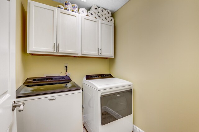 washroom with washer and dryer and cabinet space