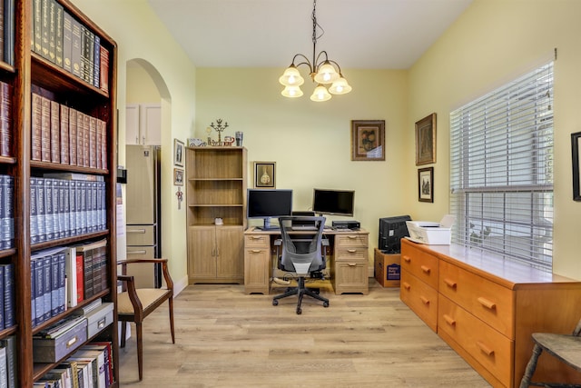 office area featuring arched walkways, light wood-type flooring, and a chandelier