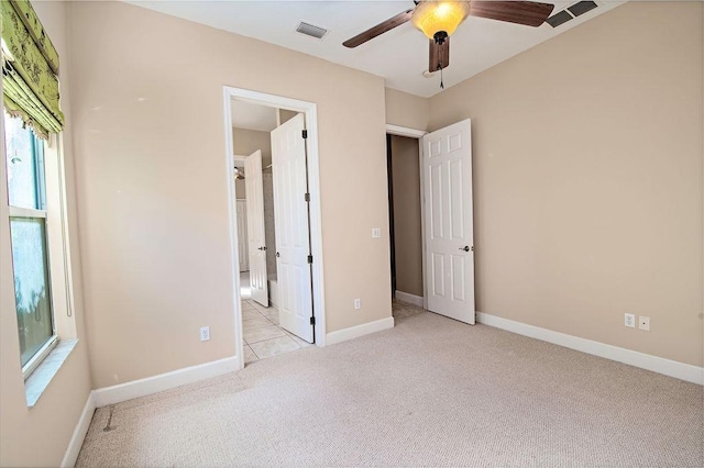 unfurnished bedroom with ceiling fan and light colored carpet