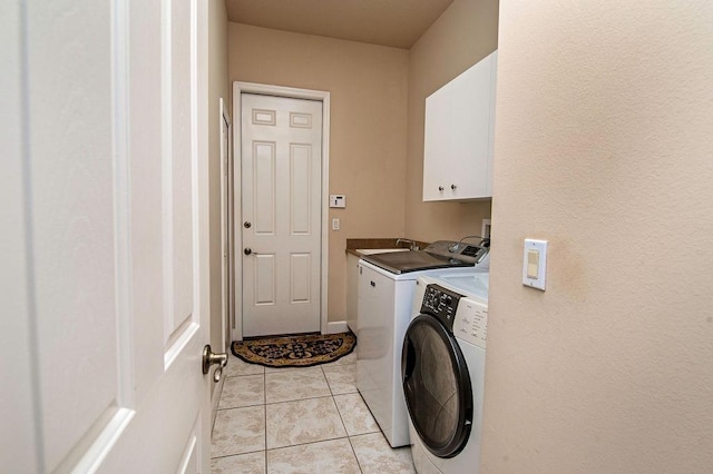 washroom with washer and dryer, light tile patterned flooring, cabinets, and sink